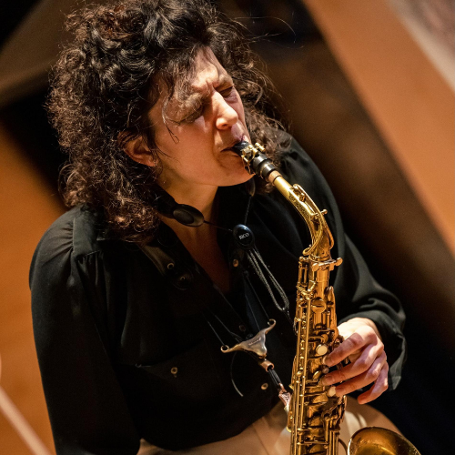 Nicola Miller plays passionately into a saxophone